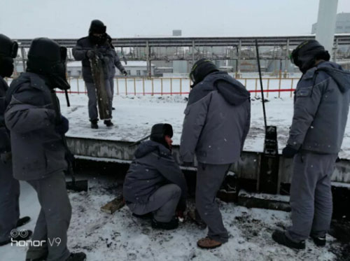 图为车间师傅在雪地调试地磅现场